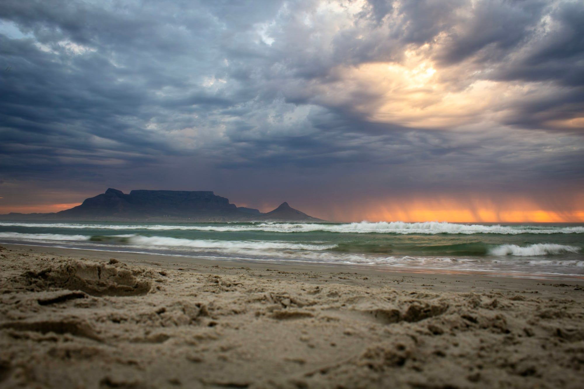 Tafelberg en Lion’s Head als silhouet onder een dramatische avondlucht